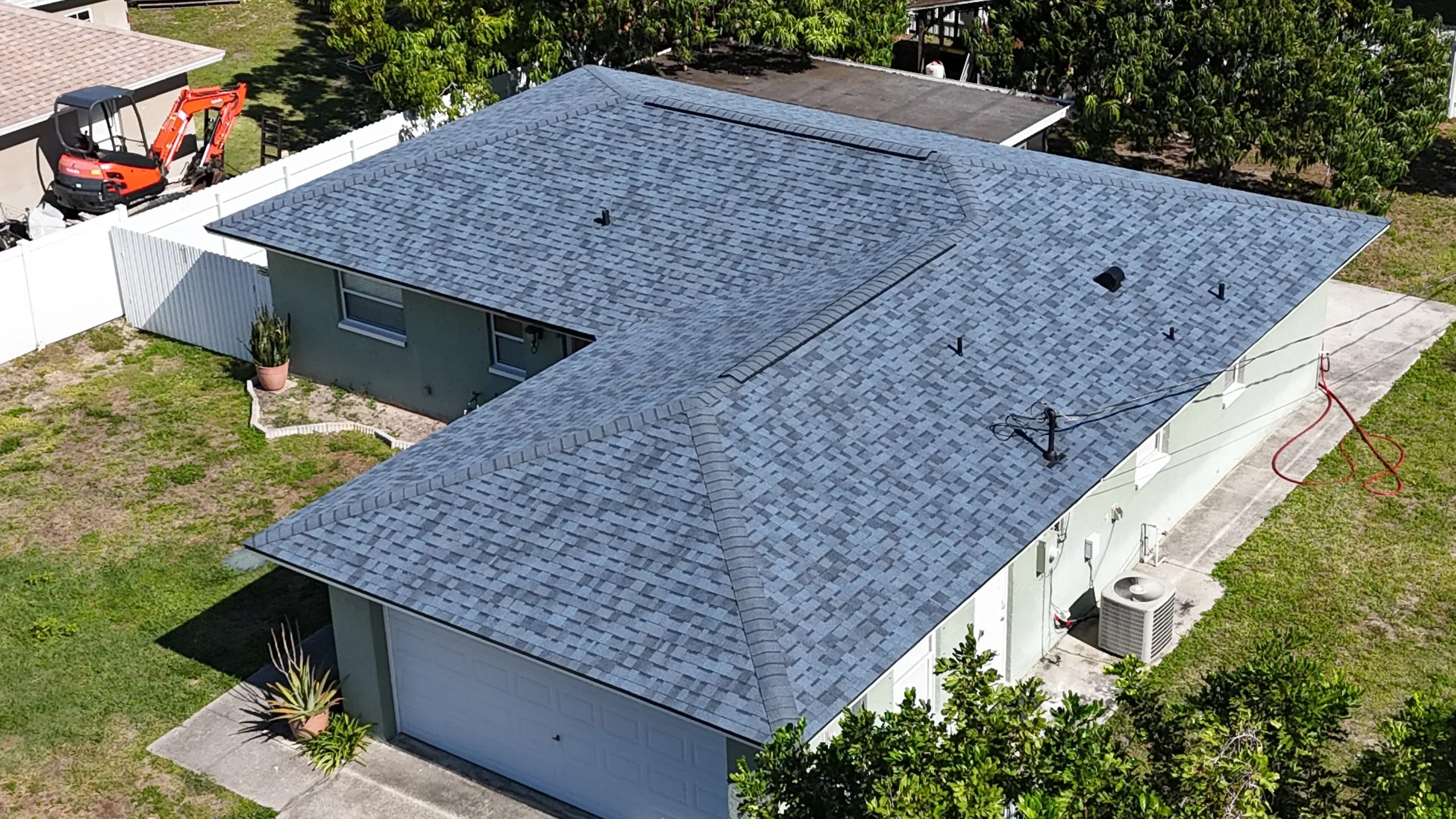 Aerial view of a residential home with a newly installed gray asphalt shingle roof